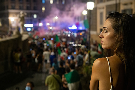 A girl watches celebrations of Italian supporters after Italy-Spain football match
