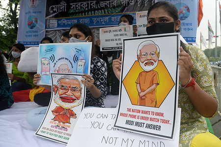 Trinamool Chatra Parishad or TMCP activists holds poster during a demonstration to protest against Pegasus snooping issue.