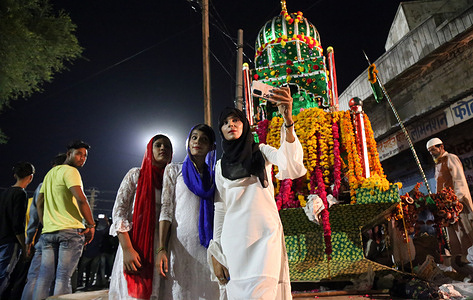 Indian muslim girls takes selfie with a traditional Tazia during Muharram procession in Beawar. Tazia is a replica of the mausoleum of Imam Hussain, the grandson of Prophet Muhammad. Muharram is the first month of the Islamic calendar. It is one of the four sacred months of the year.