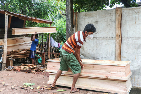A man carry coffin at a funeral shop in Moratuwa on the outskirts of Colombo.