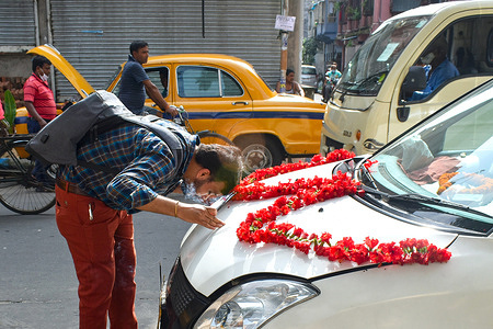 A person worships his car on the occasion of Lord Vishwakarma (The Hindu deity of architecture and machinery) festival in Kolkata.