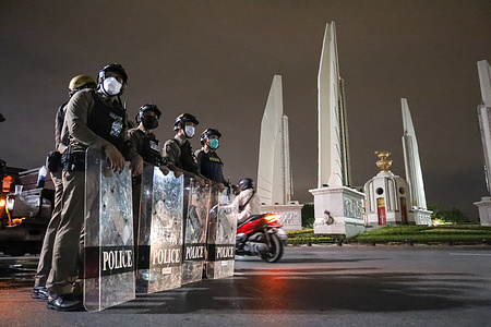 Riot police stand guard the Democracy Monument area. On the 48th anniversary of the event the 1973 Thai popular uprising.