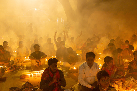 Hundreds of Hindu devotees gather in front of Shri Shri Loknath Brahmachari Ashram temple for Rakher Upobash, a religious fasting festival called Kartik Brati, in Barodi, Sonargaon, Narayanganj. Sitting in front of candle lights, they fast and pray in earnest to the gods for their favors during the ritual. The festival is held on every Saturday and Tuesday in the last 15 days of the Bengali month – “Kartik.”