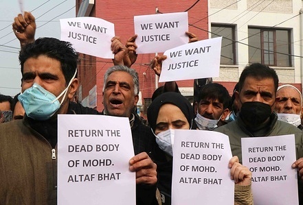 Relatives of slain civilian Mohammad Altaf Bhat raise placards during a demonstration demanding the return of the bodies of Altaf and Mudasir who, according to the police, was killed during a gun battle between militants and Indian security forces.