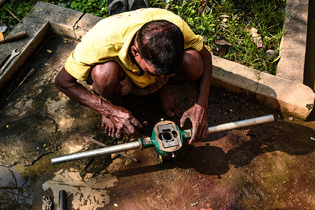 A recent report published by the Reserve Bank of India (RBI) shows that the daily wage of rural workers in West Bengal is way below the national average. A worker is repairing a tubewell (hand pump) at Tehatta, West Bengal.