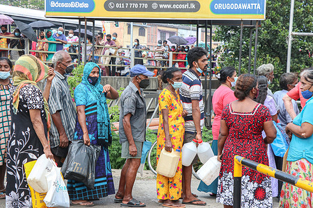 People stand in a queue to buy kerosene in Colombo