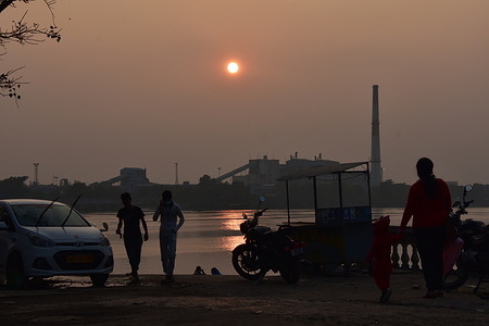 People are enjoying scenic beauty of the setting sun over the Ganges on the last day of calendar year 2021.