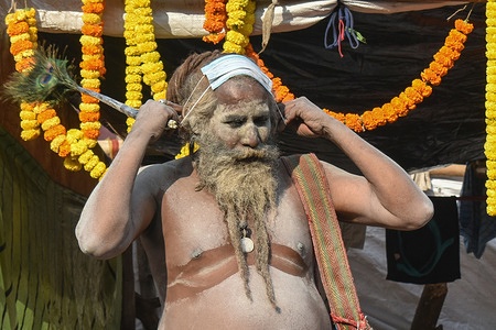 A Hindu holy man, or Naga Sadhu put-up his face mask on his head at a base camp where pilgrims gather before heading for an annual trip to Sagar Island for the one-day festival of "Makar Sankranti", amidst the spread of the coronavirus disease (COVID-19), in Kolkata.