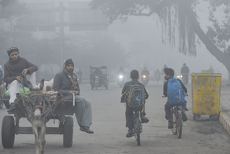 Pakistani citizens, students on their way during a cold and dense foggy morning in Lahore. Pakistani residents and commuters are more worried than surprised due to the sudden layer of dense smog which is causing problems in respiration, visibility and has also hampered smooth flow of traffic, residents of Lahore woke up to a dense blanket of smog on Thursday that reduced visibility for commuters and prompted several complaints of respiratory problems and mental anguish.