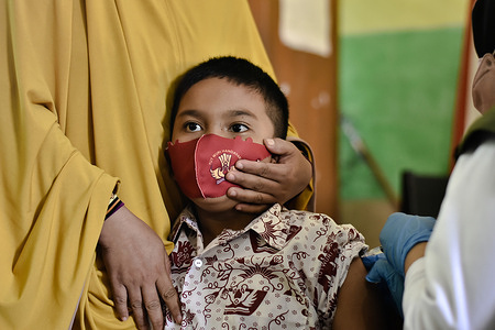An elementary school student receives the first dose of the COVID-19 vaccine at an elementary school in Soppeng Regency. The Indonesian government implement a vaccination program for ages 6-11 years in an effort to encourage the optimization of face-to-face learning.