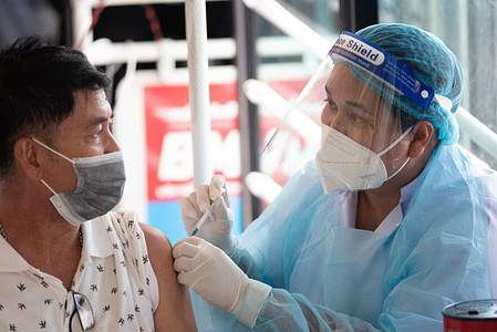 medical staffVaccinating for COVID-19to the public at the BKK Mobile Vaccination Unit (BMV), which stopped in Bangkok Suksa School, Lat Phrao Road, Bangkok, Thailand on January 16, 2022.