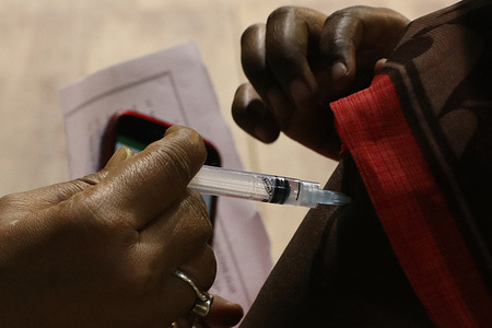 A health worker inoculates a man with the booster dose of Covishield vaccine against the Covid-19 at vaccination camp in Kolkata