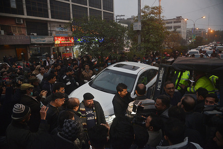 Pakistani Police officer and journalists gather around the car of local journalist Husnain Shah at the site of shooting incident in Lahore. Unidentified gunmen riding on a motorcycle shot and killed Husnain Shah in the city of Lahore on Monday before fleeing the scene, a police official and representatives of journalists said.