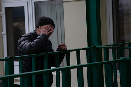 On the Ukrainian side of the border a man cries as he says goodbye to his wife crossing into Poland.