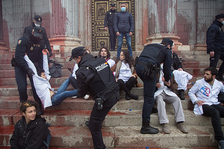 Activists from the international collective Scientists Rebellion and Extinction Rebellion fill the façade of the Congress of Deputies in Madrid with biodegradable fake blood against the climate crisis.