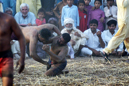 Pakistani traditional wrestlers busy in free wrestling (Open Kabaddi) match in wrestling pits (Akhara) during 498th urs celebrations of Pir Ahmed Hasan known as a Mialay Shah in Jandraka city dist Okara some 150km from Lahore. 'Kushti', the traditional wrestling is one of the most popular games in Pakistan. Thousands of years ago when there was no cricket, no hockey, no football, the most enjoyable hobby of the people was wrestling. Even today after the introduction of so many kinds of sporting activities around the world, the sport of wrestling draws more crowds then any other sport because, fighting is a part of human nature. There are different styles of wrestling in the world today but the most famous among them is the Freestyle Wrestling. Pakistan had a great past in traditional wrestling also called as desi kushti. Kushti, an Indo-Pakistani form of wrestling, is several thousand years old and is a national sport in Pakistan.