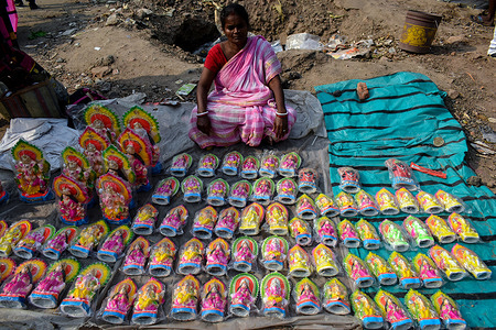 A woman selling Laxmi and Ganesha idol in front a temple on the occasion of Bengali New Year in Kolkata.