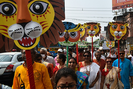 People holding masks join a rally to celebrate the first day of the Bengali New Year, in Kolkata.