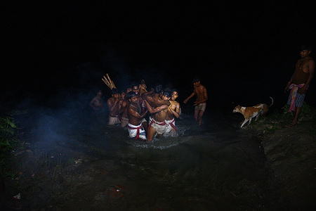 The 'Hajrha Bhasan' ritual is part of the rural Bengal Gajan festival where at midnight (1:27 AM) a devoted monk would try to escape by jumping to the Jalangi river without safety according to the ritual and the rest of the monks would catch him and take him along the banks of the river and run straight to his destination in the split second. This photo was taken at Tehatta, West Bengal.
