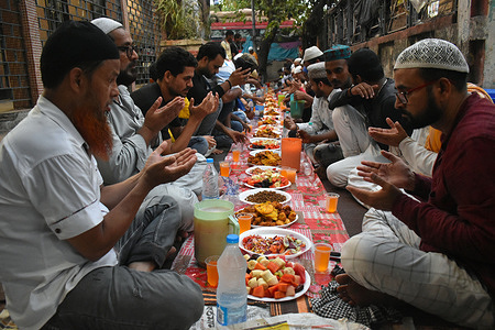 Muslim men prays before eating his Iftar (breaking fast) meal on a roadside during the holy fasting month of Ramadan.