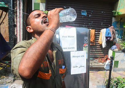 A gas delivery man was drinking cold water from a freeze which was installed by local people in a hot summer days.
Tauseef Rahman,a local resident in Kolkata, took an initiative to distribute frozen water to passersby on hot summer days.That's why he put his house freeze on the road for the people who are thirsty on hot summer days. It will remain for 28 days. Every day he keeps more than 30 water bottles in this freeze.