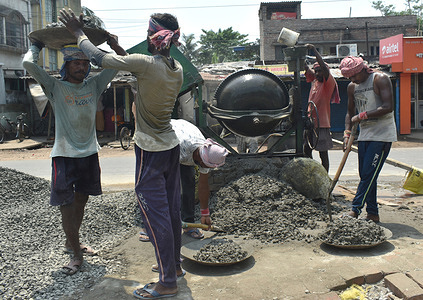 Labourers work at the construction site on the day of 'International Workers Day' on the outskirts of Kolkata.