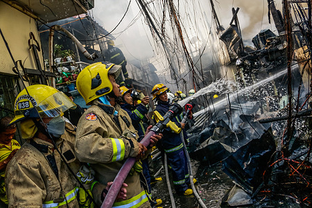 Firefighters responds on a fire hits residential area in Manila, Philippines on May 4, 2022. 4th of May is the celebration of International Firefighters' Day.