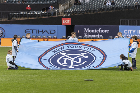 Young boys holds NYCFC flag at ceremony before regular MLS game against Sporting Kansas City at Citi Field. Game ended in goalless draw.