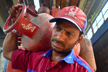 A person carrying a gas cylinder on his shoulder for delivery during the high gas price in Kolkata.