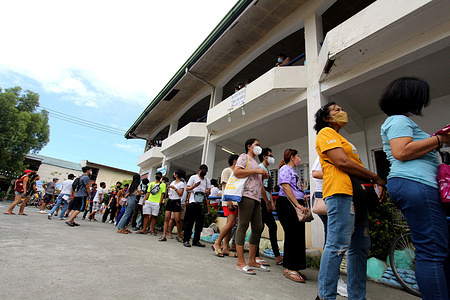 Voters queuing outside the school building and waiting their turn to cast their vote for 2022 Philippine National elections at Cainta Elementary School in Cainta Rizal on May 9, 2022.