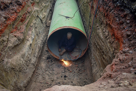 A workman welds a water pipe on the outskirts of Kolkata, India.