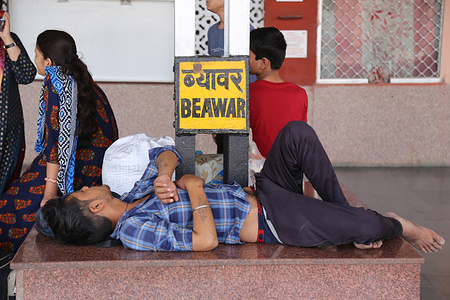 Passenger rest as they wait for train on a hot summer day at railway station in Beawar.