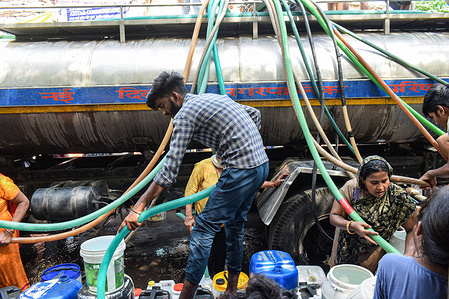 People fill water containers with drinking water from a Municipal Water Tanker outside a slum cluster in New Delhi. The demand for drinking water has increased due to many heatwaves in Delhi.