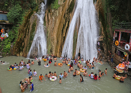 People bathe at Kempty waterfall to beat the heat during summer season in Mussoorie. Tourists from across the country arrives here to celebrate weekend.