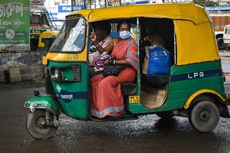 A woman is wearing a protective mask while riding in an auto amid the surge of Covid-19 in Kolkata.