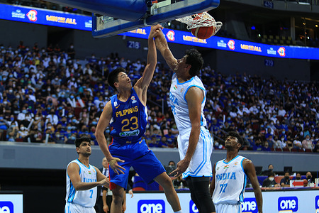 Will Navaro (23, Blue) dunks the ball over an Indian player.