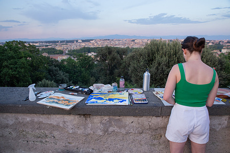 Some foreign girls paint at sunset on the Janiculum terrace in Rome. on a hot summer day
