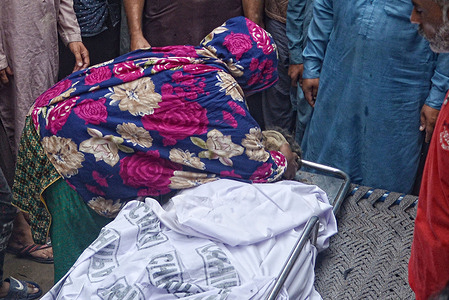 Pakistani relatives carry the body of a man who died when the roof of his house collapsed due to heavy rains fall in Lahore. The latest spell of monsoon rain has broken a 20-year record as the provincial capital received 234mm of downfall in seven hours. atleast Six persons dead and Ten injured atfer two roof collaps and other incidents in provincial capital city Lahore.