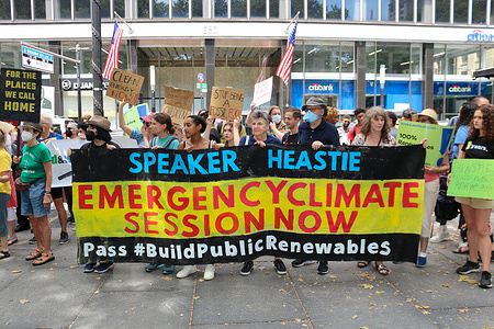 Demonstrators hold signs and banner in front of the City Hall in New York City demanding public renewables for climate justice on July 27, 2022.