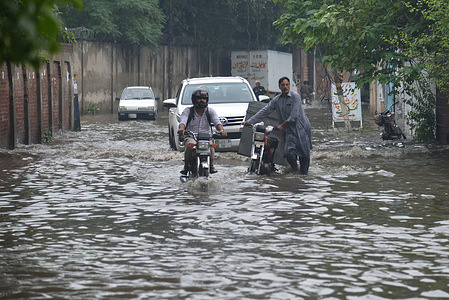 Pakistani people wade through a flooded road with difficulty after heavy rainfall in Lahore. The latest spell of monsoon rain has broken a 20-year record as the provincial capital received 234mm of downfall in seven hours.