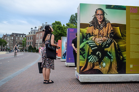 A woman observes the outdoor photography exhibition that celebrates diversity in Museum Square. Amsterdam prepares for the its world-famous gay pride Canal Parade with art exhibitions that celebrate diversity and also denounce discrimination and the countries who criminalize homosexuality.