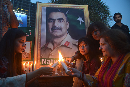 Pakistani members of civil society group participate in a candle light vigil to pay tribute to army officers who were killed in a helicopter crashed while flying on a relief mission in a flood-hit area in the country's southwest Baluchistan” at Liberty Chowk in Provincial Capital city Lahore.