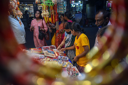 Women shop at a stall selling "rakhis" or traditional Indian sacred threads at a market in Kolkata.