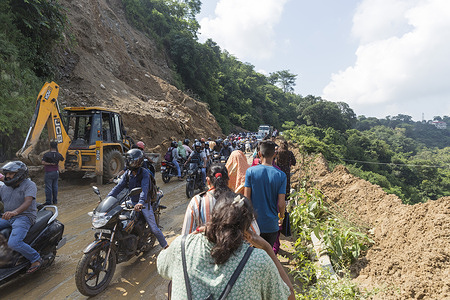 JCB machine clearing the mud as bike riders and other vehicles trying to pass the mud area after landslide at Kuthman, on Pathankot-Mandi National Highway, near Gaggal, 15 km away from Dharamshala on Monday. There was 5 km long jam both side from landslide area.