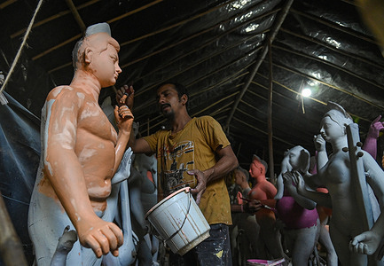 An artist gives final touches to an idol of Hindu Goddess Durga in a workshop ahead of the 'Durga Puja' festival.