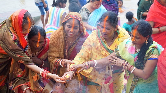 Women taking a bath at the holy river Ganga and doing Puja after at the Ghat of Ganga. Women keeping fast for good health and longevity of their son.