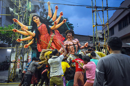Laborers pull an idol of Durga, through a street to be transported on a trolly to a pandal, or a temporary platform, for the upcoming festival of Durga Puja in Kolkata.