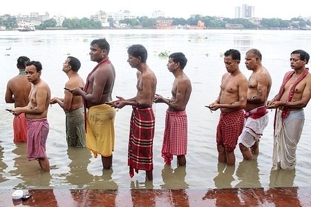 People of Kolkata are performing Tarpana at Ganga river. Tarpana is a term in the Vedic practice that refers to an offering made to divine entities. It refers to the act of offering as well as the substance used in the offering. Tilatarpana is a specific form of tarpana involving libations offered to the pitri (deceased ancestors) using water and sesame seeds during Pitru Paksha or as a death rite. Tarpana is a form of arghya (an offering). It is offered to all devas as well as the Navagrahas whenever mulamantra is recited as japa.