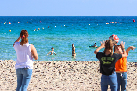 People enjoying beach of Mondello on an autumn day, is a small seaside resort near center of city Palermo.