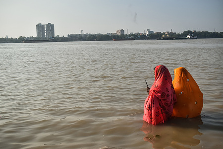 Hindu women worship the Sun god in the banks of river Ganga at Kolkata.